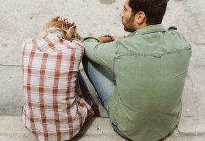 Man and woman sitting on curb